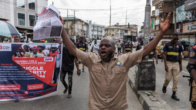 Un manifestant tient un journal lors de la manifestation nationale du Joint Action Front (JAF) et de la Coalition for Revolution (CORE) contre les politiques du président nigérian Bola Tinubu, à Lagos, le 26 février 2024.