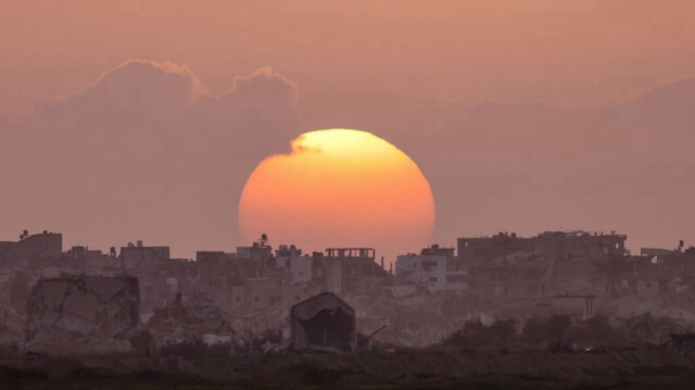 Le coucher de soleil derrière des logements détruits par les bombardements de l'armée d'occupation israélienne à Gaza, en Palestine, le 3 mars 2024.