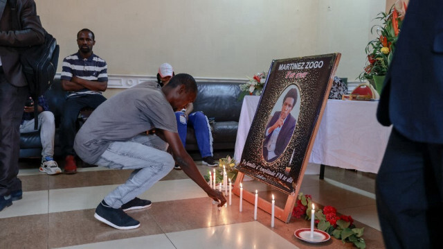 Une personne en deuil dépose une bougie dans une salle de la Radio Amplitude FM où un portrait du journaliste Martinez Zogo a été placé pour lui rendre hommage, au quartier Elig Essono à Yaoundé, le 23 janvier 2023.
