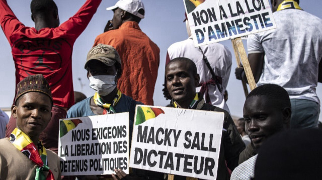 Des manifestants brandissent des pancartes lors d'une marche à Dakar le 02 mars 2024, contre la nouvelle loi d'amnistie et pour la tenue d'élections avant le 02 avril 2024. 