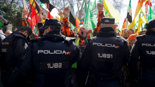 Des agriculteurs protestent face à des policiers lors d'une manifestation dénonçant leurs conditions de travail et la politique agricole européenne, à Madrid, en Espagne, le 26 février 2024. 