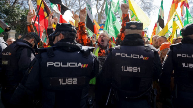 Des agriculteurs protestent face à des policiers lors d'une manifestation dénonçant leurs conditions de travail et la politique agricole européenne, à Madrid, en Espagne, le 26 février 2024.