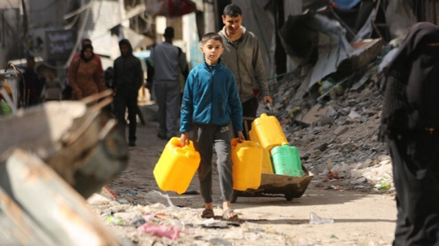 Les Palestiniens transportent et remplissent des jerricans d'eau à partir des quelques sources d'eau souterraines et de réservoirs mobiles, dans la ville de Gaza, le 03 mars 2024.