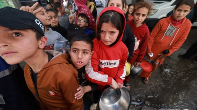 Des enfants palestiniens reçoivent des rations de nourriture cuisinée par des organisations caritatives à Gaza, le 05 mars 2024.