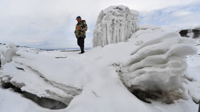 L'agriculteur Erkinbek Kaldanov, âgé de 54 ans, inspecte un glacier artificiel dans une gorge de montagne près du village de Syn-Tash, à environ 60 km de Bichkek, le 13 février 2024.