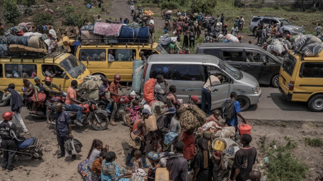Des gens se rassemblent sur une route animée alors qu'ils transportent certains de leurs biens en fuyant le territoire de Masisi suite à des affrontements entre les rebelles du M23 et les forces gouvernementales, sur une route près de Sake le 7 février 2024. 