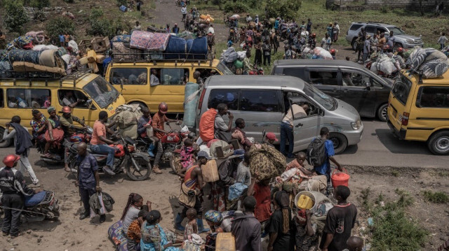 Des gens se rassemblent sur une route animée alors qu'ils transportent certains de leurs biens en fuyant le territoire de Masisi suite à des affrontements entre les rebelles du M23 et les forces gouvernementales, sur une route près de Sake le 7 février 2024.