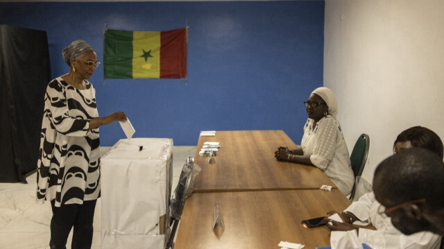 Une femme vote dans un bureau de vote fictif mis en place par les membres du groupe de la société civile Aar Sunu Election (Protégeons nos élections) pour que les gens exercent leur droit de vote à Dakar, le 25 février 2024.