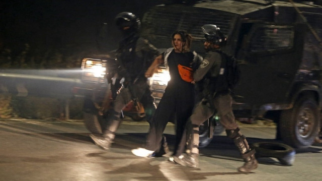 Des soldats de l'armée israélienne arrêtent une femme palestinienne lors d'une manifestation en Palestine occupée.