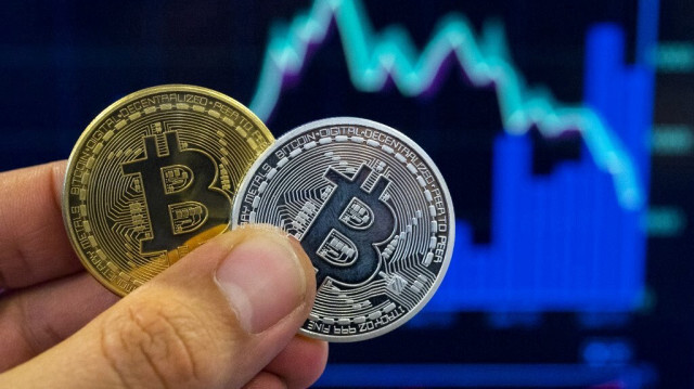 Cette photo prise le 6 février 2018 montre une personne tenant une représentation visuelle de la crypto-monnaie numérique Bitcoin.