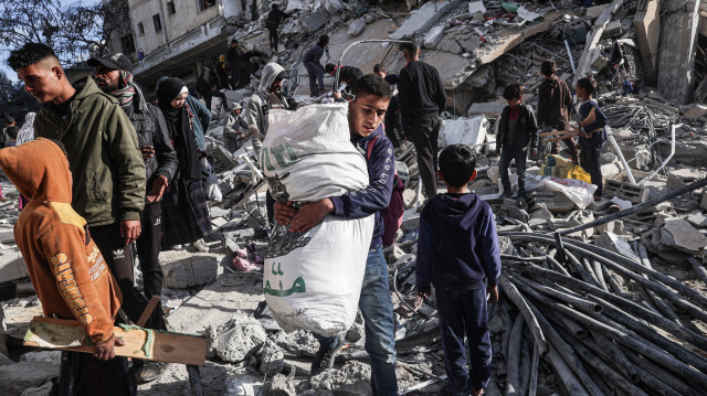 Un jeune Palestinien s'éloignant avec des objets récupérés dans les décombres d'un immeuble résidentiel touché par une frappe aérienne israélienne à Rafah, dans le sud de la bande de Gaza, le 9 mars 2023.