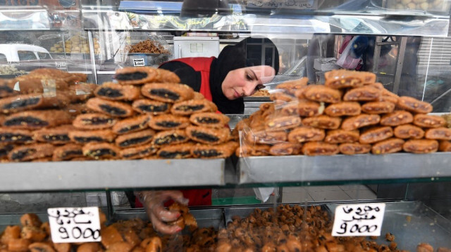 Un employé sert une pâtisserie à un client dans une boulangerie de Tunis pendant le mois de jeûne musulman du Ramadan, le 29 mars 2024, dans un contexte de pénurie de sucre dans le pays.