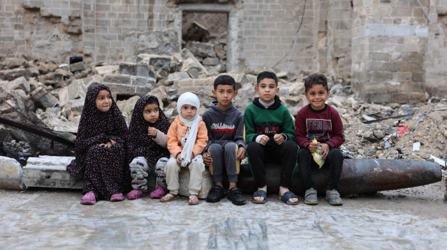 Des enfants palestiniens posant pour une photo le 10 avril 2024 dans la cour de la mosquée historique Omari de la ville de Gaza, qui a été fortement endommagée par les bombardements israéliens pendant les batailles en cours entre Israël et le Hamas, après la prière du matin le premier jour de l'Aïd al-Fitr qui marque la fin du mois de jeûne du Ramadan.