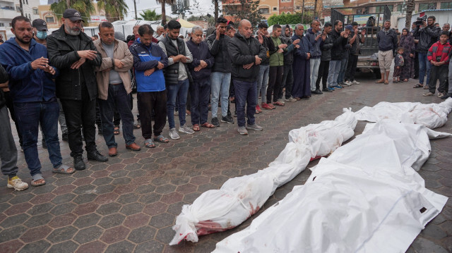 Des Palestiniens priant près des corps des victimes d'une famille tuée lors d'un bombardement israélien sur le camp de réfugiés de Nuseirat dans le centre de Gaza, le premier jour de la fête de l'Aïd al-Fitr marquant la fin du mois sacré du Ramadan, lors de leurs funérailles à l'hôpital des martyrs d'al-Aqsa à Deir el-Balah, le 10 avril 2024, dans le cadre du conflit actuel entre Israël et le groupe militant palestinien Hamas.