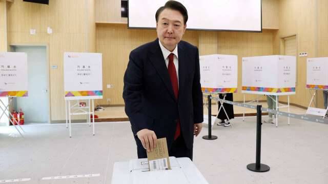 Le président sud-coréen Yoon Suk Yeol déposeant son bulletin de vote lors du vote anticipé dans un bureau de vote à Busan le 5 avril 2024, avant les élections législatives de la semaine prochaine. Les Sud-Coréens peuvent voter pour les prochaines élections législatives du 10 avril pendant la période de vote anticipé de deux jours jusqu'au 6 avril.