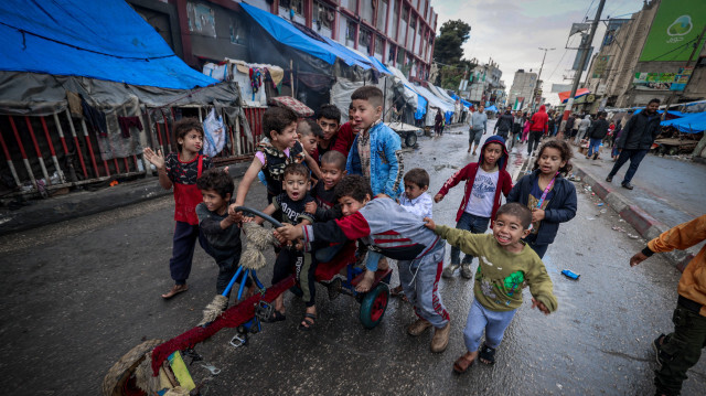 Des enfants déplacés jouant dans une rue à côté de leurs tentes le premier jour de la fête de l'Aïd al-Fitr, qui marque la fin du mois sacré du Ramadan, à Rafah, dans le sud de la bande de Gaza, le 10 avril 2024, alors que le conflit entre Israël et le groupe militant palestinien Hamas se poursuit.