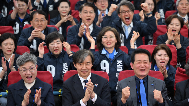 Cho Kuk (au centre), leader du parti sud-coréen Rebuilding Korea, et les membres de son parti réagissent en regardant les télévisions diffusant les résultats des sondages de sortie des urnes pour les élections législatives à l'Assemblée nationale à Séoul le 10 avril 2024.