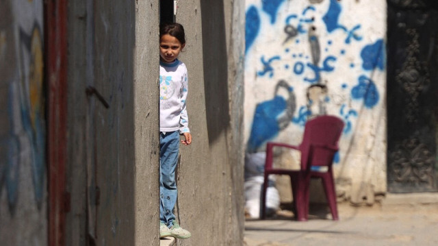 Une jeune fille palestinienne se tient à l'entrée d'un bâtiment, dans le camp de réfugiés de Nuseirat, au centre de Gaza, le 12 avril 2024.
