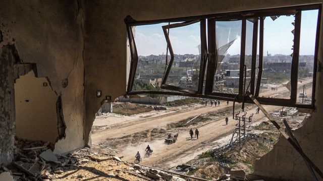 Des Palestiniens traversAnt une rue près de bâtiments endommagés à Khan Yunis le 7 avril 2024, après qu'Israël a retiré ses forces terrestres du sud de la bande de Gaza, six mois après le début de la guerre dévastatrice déclenchée par les attaques du 7 octobre. Israël a retiré toutes ses troupes du sud de la bande de Gaza le 7 avril, y compris de la ville de Khan Yunis, selon l'armée et les médias israéliens, après des mois de combats acharnés avec les militants du Hamas qui ont dévasté la région.