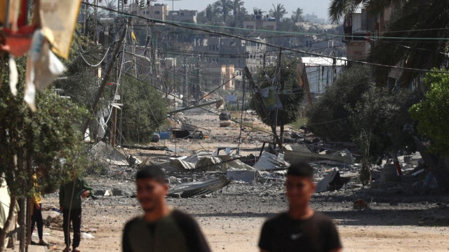 Des Palestiniens marchent près des débris de bâtiments détruits lors de bombardements israéliens à Nuseirat, au centre de Gaza, le 12 avril 2024.