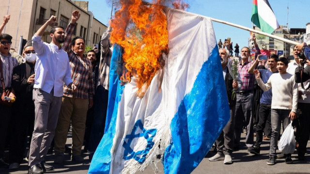 Des manifestants brûlent un drapeau israélien lors des funérailles de sept membres du Corps des gardiens de la révolution islamique tués lors d'une attaque en Syrie, que l'Iran a imputée à Israël, à Téhéran, le 5 avril 2024.