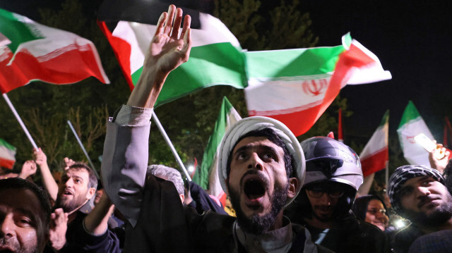 Des manifestants brandissant le drapeau iranien et des drapeaux palestiniens alors qu'ils se rassemblent devant l'ambassade britannique à Téhéran le 14 avril 2024, après que l'Iran a lancé une attaque de drones et de missiles contre Israël. Les Gardiens de la révolution iraniens ont confirmé le 14 avril 2024 qu'une attaque de drones et de missiles était en cours contre Israël, en représailles à l'attaque meurtrière du 1er avril contre le consulat de Damas.
