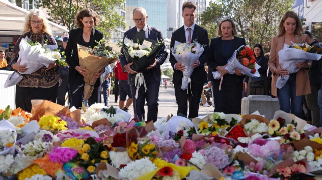 Le Premier ministre australien Anthony Albanese se tient aux côtés du premier ministre de la Nouvelle-Galles du Sud, Chris Minns et d'autres responsables alors qu'ils se préparent à laisser des fleurs à l'extérieur du centre commercial Westfield Bondi Junction à Sydney le 14 avril 2024.