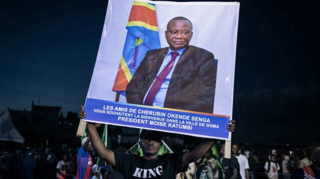 Un homme porte une affiche à la mémoire de Cherubin Okende qui a été assassiné en juillet 2023 dans des circonstances obscures, lors du meeting électoral de Katumbi dans un stade de Goma, l'une des plus grandes villes de l'est de la RDC, le 23 novembre 2023.