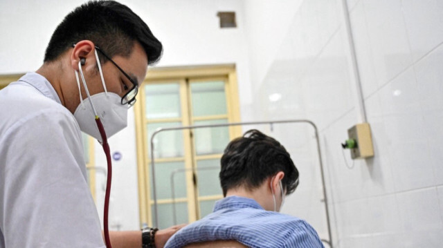Le médecin vietnamien Truong Duc Thai vérifiant un patient tuberculeux résistant aux médicaments à l'hôpital national du poumon de Hanoi, au Vietnam.