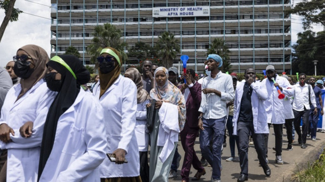 Des médecins kényans chantent en marchant vers le siège du ministère de la Santé, brandissant des pancartes pour demander de meilleurs salaires et conditions de travail, à Nairobi, le 16 avril 2024. 