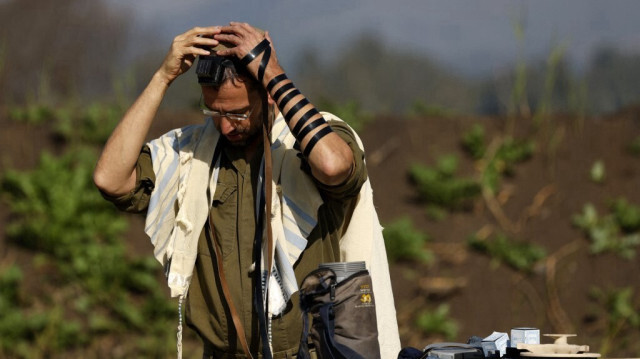 Un soldat israélien portant un châle de prière juif dans une unité d'artillerie dans le nord d'Israël, près de la frontière avec le Liban, le 4 janvier 2024.