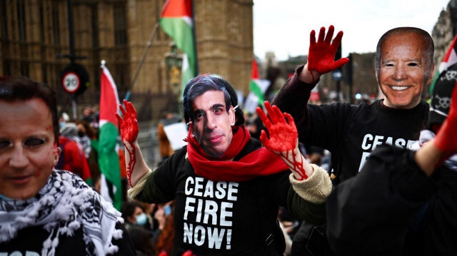 Des manifestants pro-palestiniens portant des masques représentant le ministre britannique des Affaires étrangères, David Cameron, le Premier ministre britannique, Rishi Sunak et le président américain, Joe Biden, défilant devant le Palais de Westminster, lors d'une mobilisation dans le centre de Londres le 6 janvier 2024, appelant à un cessez-le-feu immédiat à Gaza.