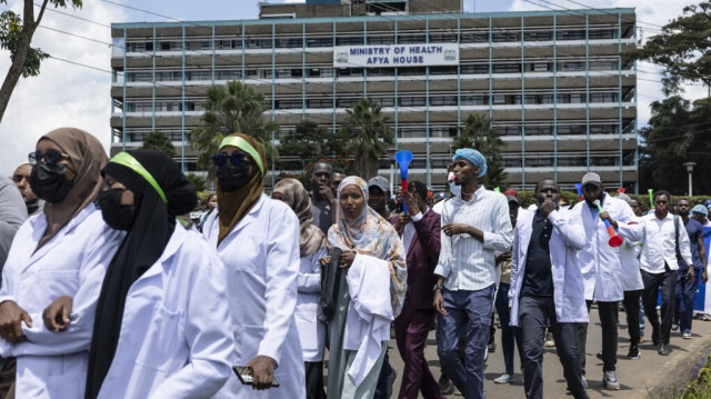Des médecins kenyans chantent alors qu'ils se dirigent vers le siège du ministère de la santé en manifestant avec des pancartes pour demander de meilleurs salaires et conditions de travail dans la capitale, Nairobi, le 16 avril 2024. 