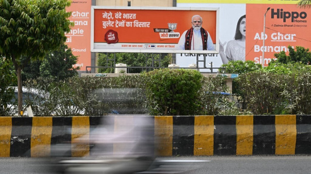 Un panneau d'affichage avec une photo du Premier ministre indien Narendra Modi est affiché le long d'une route à Noida le 19 avril 2024.