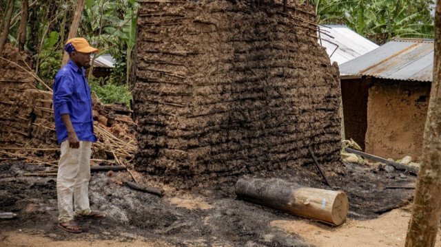 Un habitant se tient devant les débris de sa maison incendiée après une attaque attribuée aux ADF à Mukondi, à environ 30 kilomètres de la ville de Beni dans l'est de la République démocratique du Congo, le 10 mars 2023.