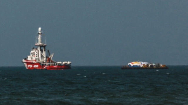 Un navire Open Arms et une barge transportant de l'aide humanitaire pour la bande de Gaza sont photographiés au large de la ville de Gaza alors qu'ils attendent l'autorisation d'accoster, le 1er avril 2024.