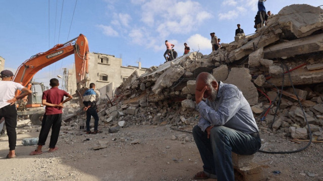 Un Palestinien attend des nouvelles de sa fille alors que des secouristes recherchent des survivants sous les décombres d'un bâtiment touché par un bombardement israélien à Rafah, dans le sud de la bande de Gaza, le 21 avril 2024.