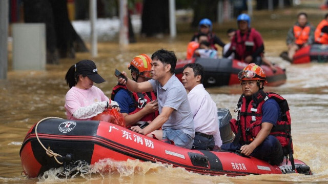 Des secouristes transportent des habitants sur des bateaux dans une rue inondée par les fortes pluies du typhon Sanba à Maoming, dans la province méridionale chinoise de Guangdong, le 21 octobre 2023.