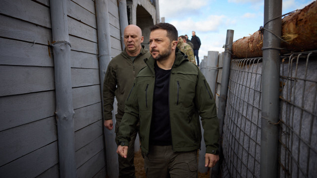 Cette photo prise et diffusée par le service de presse présidentiel ukrainien le 19 avril 2024 montre le président ukrainien Volodymyr Zelensky (à droite) inspectant la construction de fortifications à un endroit non divulgué dans la région de Donetsk, au milieu de l'invasion russe de l'Ukraine.