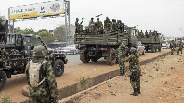 Des officiers de l'armée nigériane se tiennent à l'intérieur de véhicules militaires garés devant la Banque centrale du Nigéria (CBN) à Awka, au Nigéria, le 24 février 2023, avant les élections présidentielles nigérianes prévues pour le 25 février 2023.