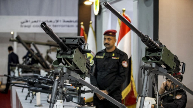 Un soldat irakien se tient près de tourelles de mitrailleuses exposées lors de l'Exposition Internationale de la Défense de l'Irak (IQDEX) 2024 à Bagdad, le 21 avril 2024.
