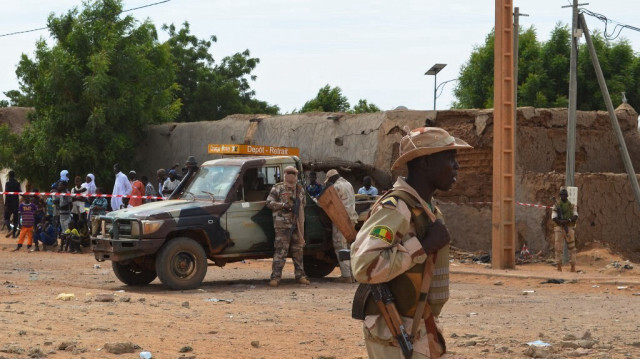 Des soldats maliens se tiennent à côté d'un bâtiment détruit le 13 novembre 2018 à Gao, après un attentat suicide à la voiture piégée qui a tué trois personnes.
