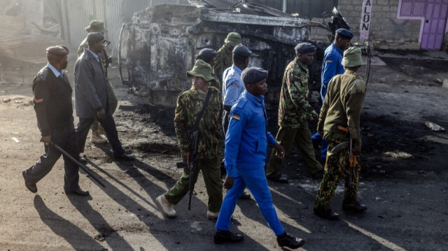 Des policiers kenyans passent devant des maisons et des magasins lourdement endommagés, un jour après une explosion de gaz dans le quartier d'Embakasi à Nairobi, le 2 février 2024.