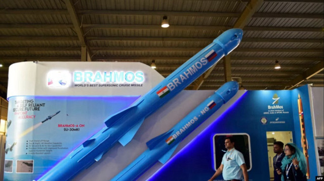 Посетители проходят мимо модели индийской сверхзвуковой крылатой ракеты "Brahmos", представленной на выставке "Defence Expo" 2022 в Гандинагаре 18 октября 2022 года.