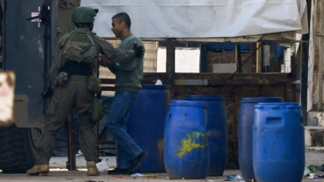 Des soldats israéliens arrêtent un homme lors d'un raid, à l'est de la ville de Naplouse, en Palestine occupée.