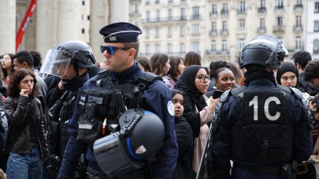 Des manifestants protestent devant des policiers français en tenue anti-émeute contre la visite du président français à l'université de la Sorbonne, à cause de sa "complicité" dans le génocide en cours à Gaza, place du Panthéon à Paris, le 25 avril 2024