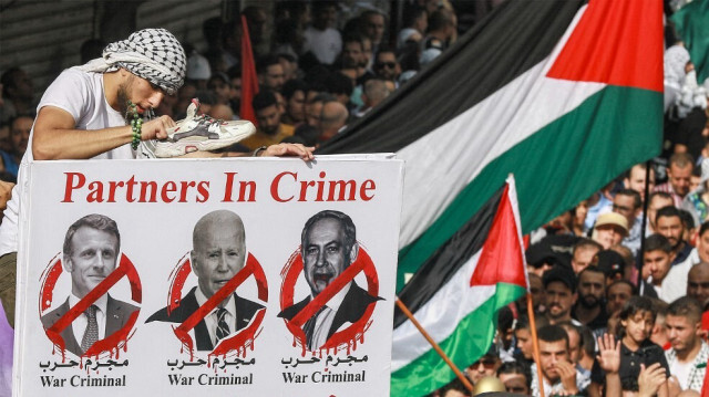 Des manifestants brandissent une pancarte condamnant le président français Emmanuel Macron, le président américain Joe Biden et le Premier ministre israélien Benyamin Netanyahu lors d'un rassemblement de solidarité avec les Palestiniens, à Amman, en Jordanie, le 27 octobre 2023.