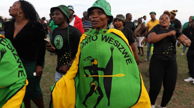 Les partisans du nouveau parti d'opposition uMkhonto we Sizwe (MK) Party chantent et scandent lors d'un rassemblement électoral devant la propriété de leur membre et ancien président sud-africain Jacob Zuma à Nkandla, KwaZulu-Natal, le 25 avril 2024.