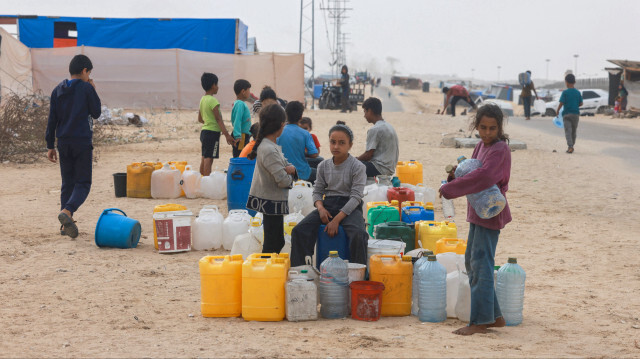 Des enfants palestiniens déplacés attendant l'approvisionnement en eau dans leur camp de tentes à Rafah, dans le sud de la bande de Gaza, le 26 avril 2024, dans le cadre du conflit entre Israël et le groupe militant palestinien Hamas.