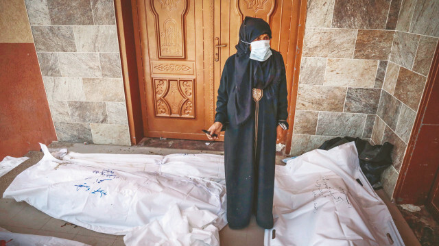Gazze'de cesetlerin arasında yaşlı bir kadın
